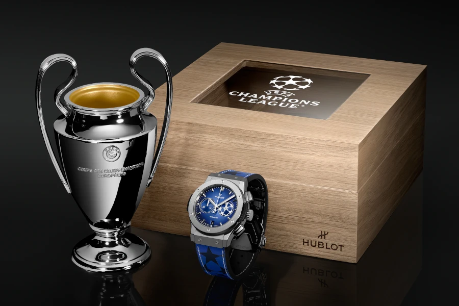 Zeitmesser und Miniatur-Replik der UEFA Champions League-Trophäe in einem maßgefertigten Holzetui